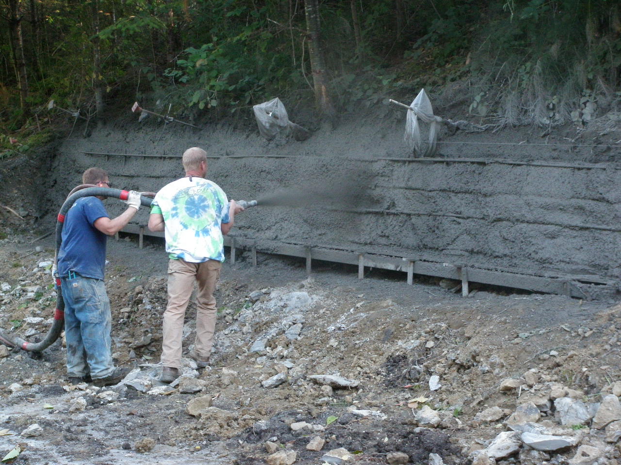 Applying shotcrete over soil nails and reinforcement
